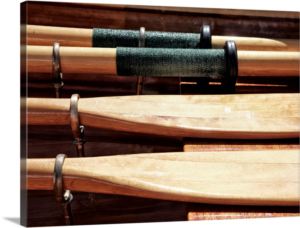 Close-up photograph of wooden oars laid out on a boat.