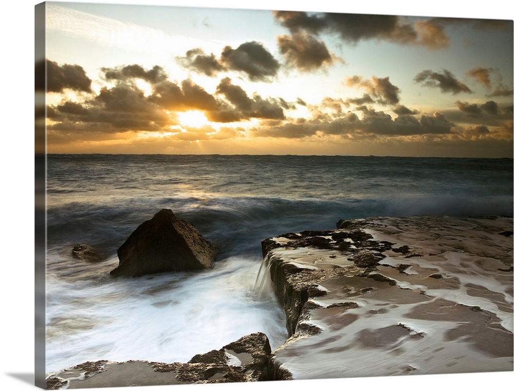 Image of a rocky coastline during a cloudy sunset.