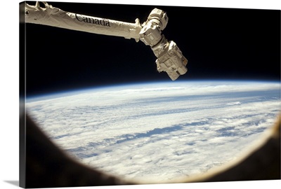 Canadarm2, the Space Station's main robot, reaches towards the horizon