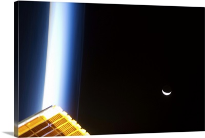 The Moon at sunrise, with blue noctilucent clouds and a solar array glowing gold