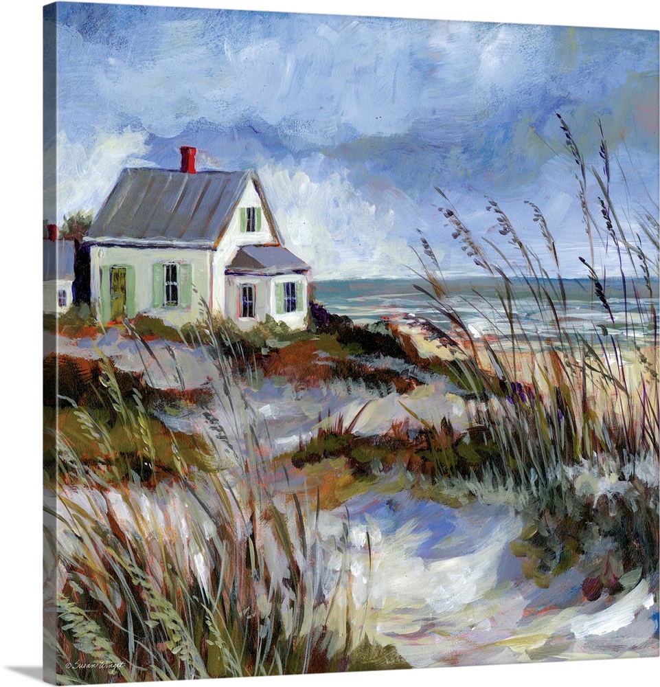 A coastal cottage sits among the dunes and water's edge.