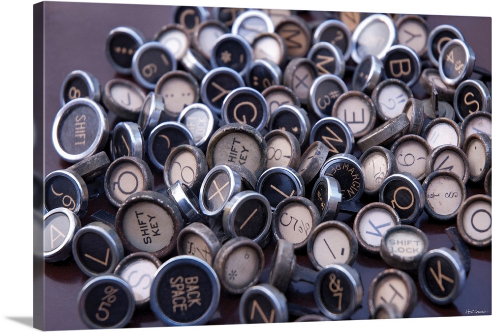 Large photograph displays the round keys of an antique typewriter spread out on a table.  The various letters, numbers, an...