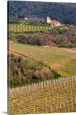 A grand stone winery stands above rolling vineyards, Chianti, Tuscany, Italy.