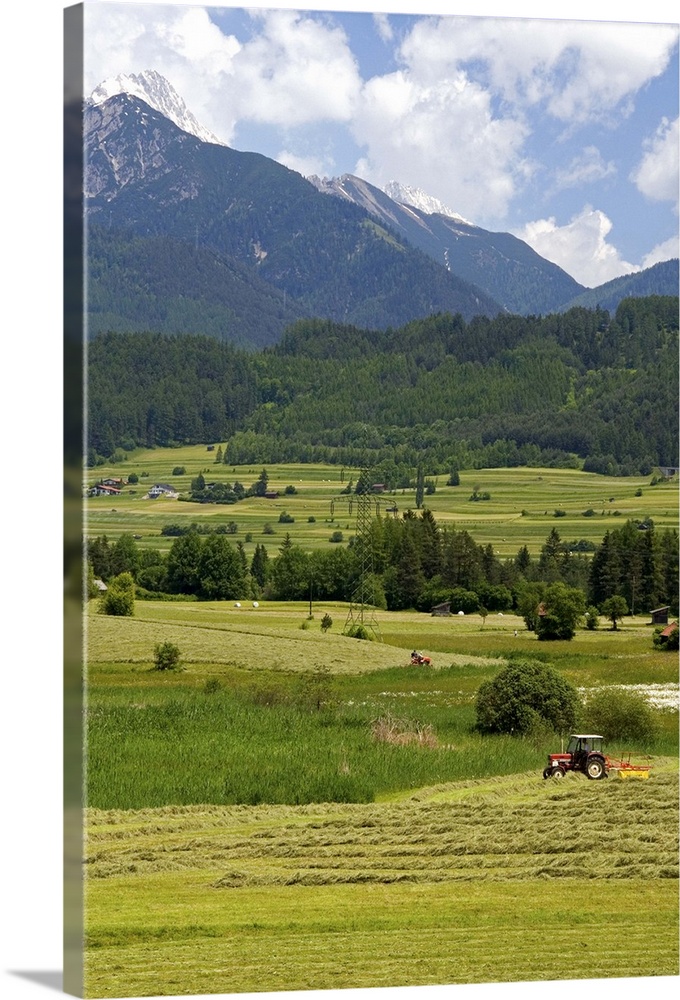 A tractor harvesting a hay field on a farm at Imst, Austria...austria, austrain, europe, european, travel, tourism, alps, ...