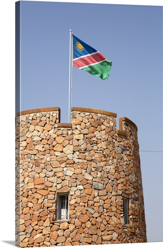 Africa, Namibia, Etosha National Park. Namibian flag flies over brick tower at park entrance.