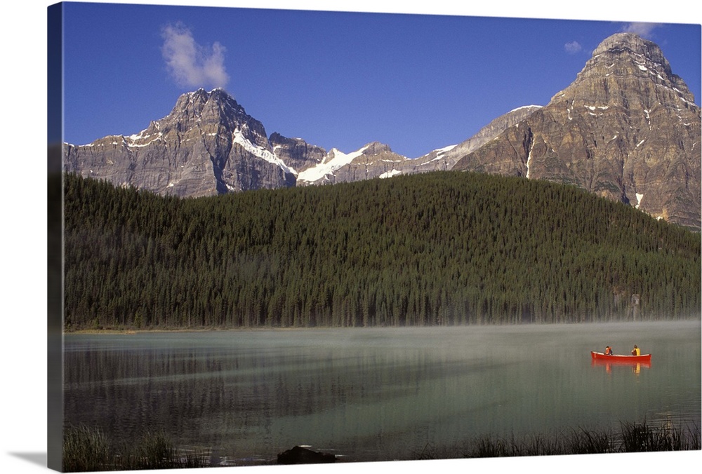 Two boys fishing from a red canoe in Waterfowl Lake, in Canada's Banff national park.