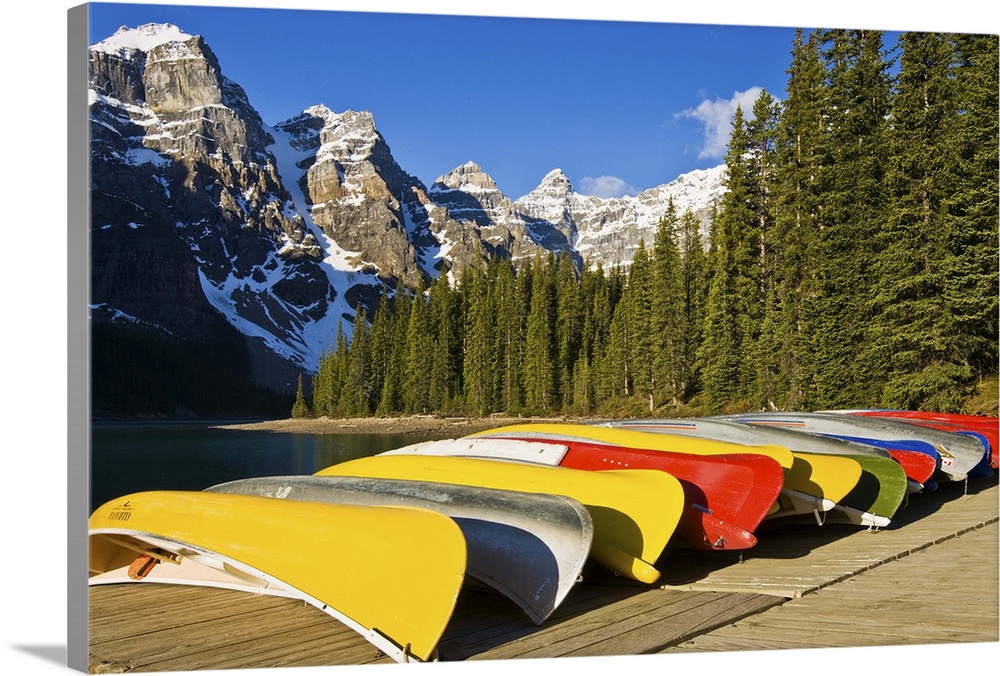 North America, Canada, Alberta, Banff National Park, Moraine Lake and rental canoes stacked on shore