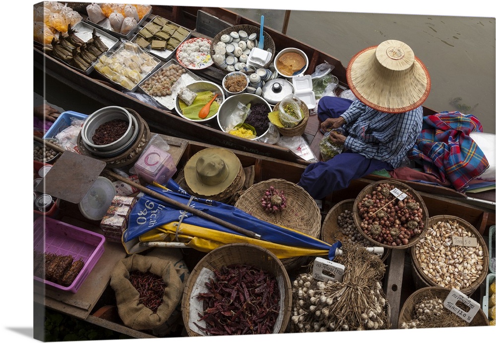 Thailand, Amphawa Floating Market. Woman prepares food for customer in her dugout canoe 'shop.'