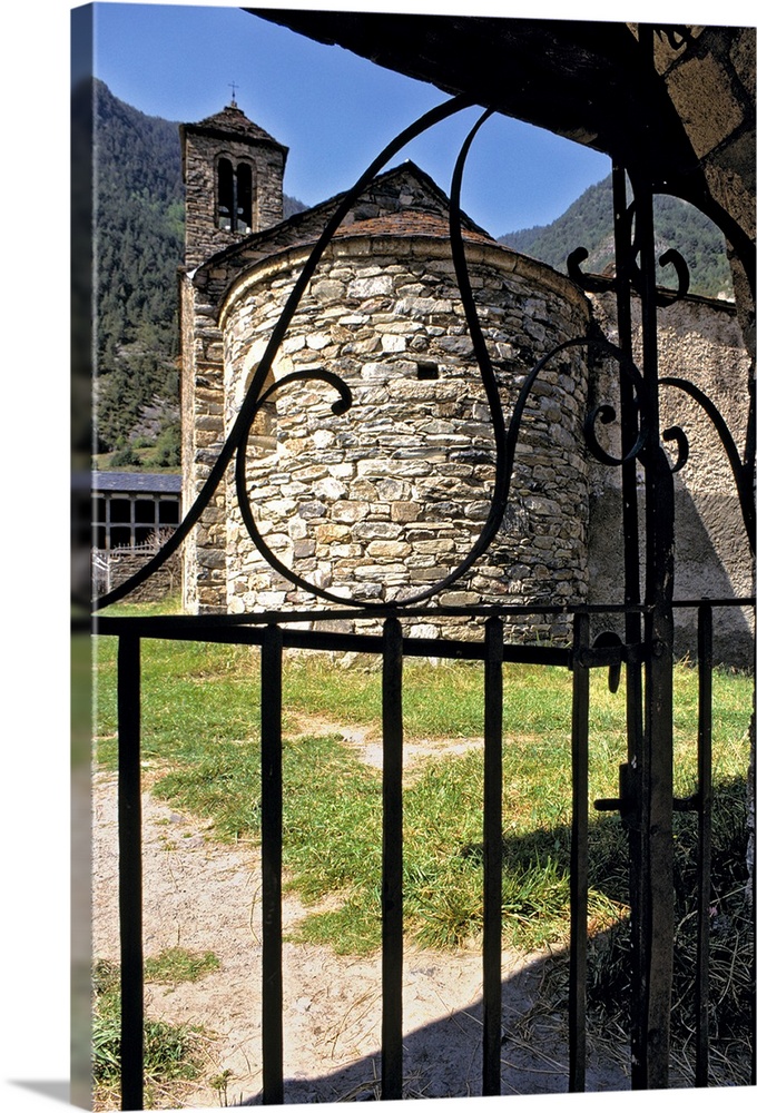 Europe, Andorra. A wrought-iron gate frames a circular stone building in Andorra.