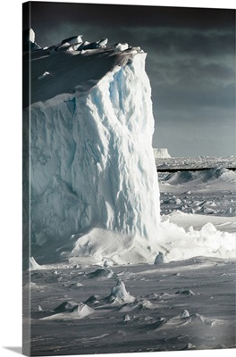 Antarctica, Iceberg at sunrise surrounded by sea ice