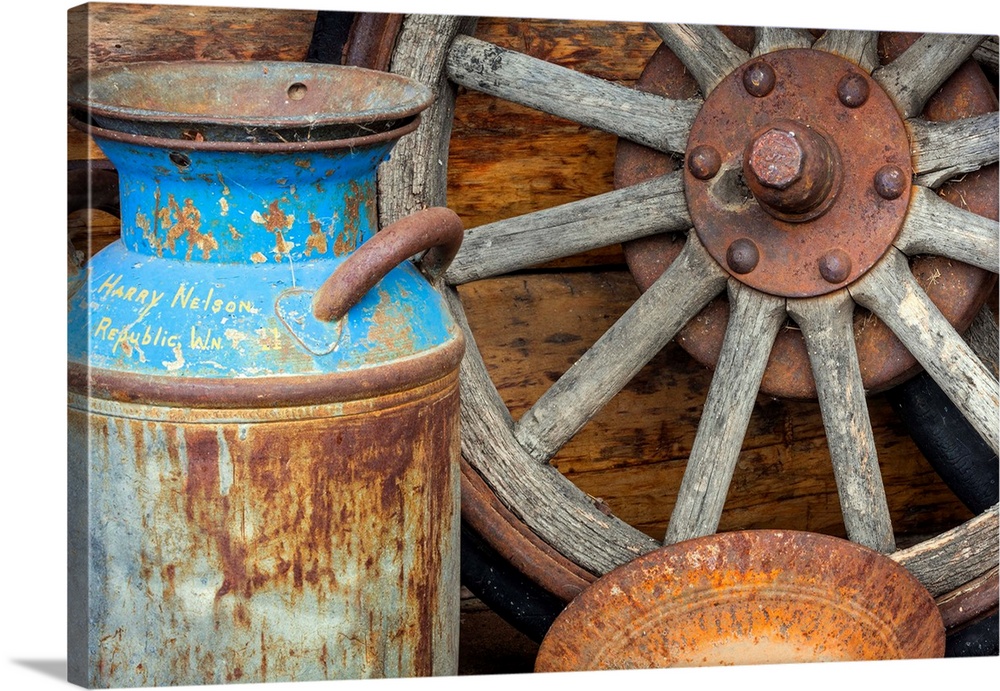 USA, Alaska. Antique milk can, wagon wheel and gold pan.