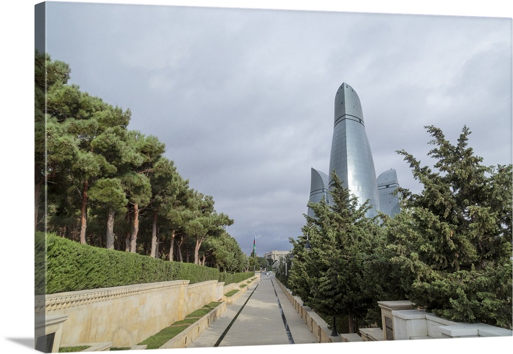 Azerbaijan, Baku. A walkway in Dagustu park, with the Flame Towers in the background.