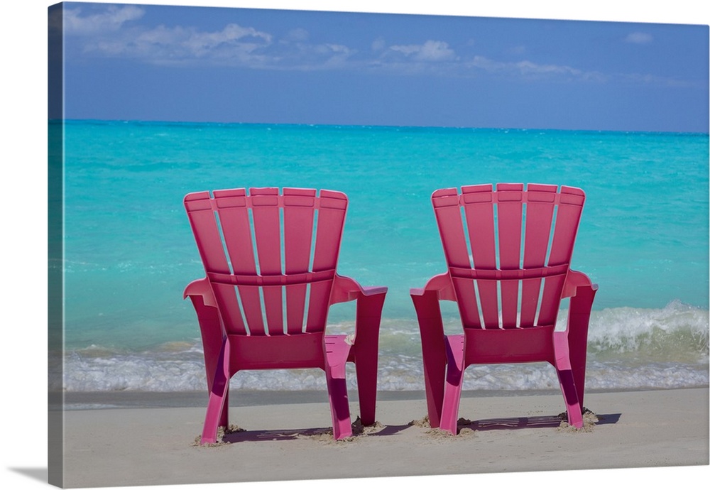 Bahamas, Little Exuma Island. Pink chairs on beach.