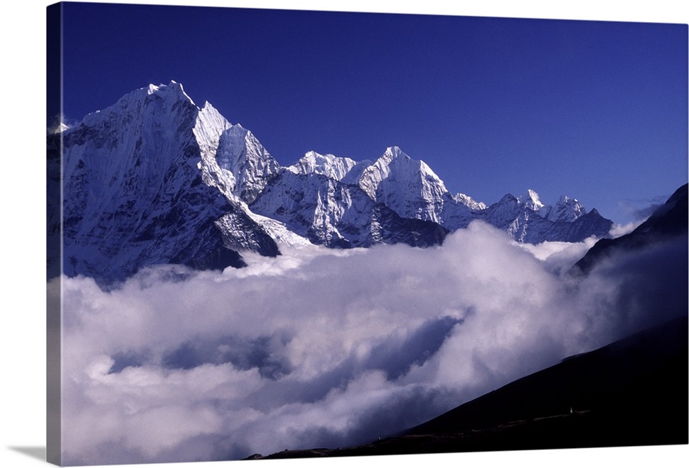 Bank of heavy clouds rolls up the Gokyo Valley under Himalayan peaks.