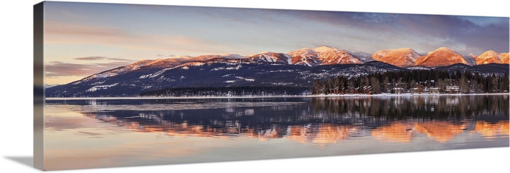 Panoramic of Big Mountain reflects into Whitefish Lake at sunset in winter in Whitefish, Montana, USA