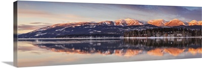 Big Mountain reflected in Whitefish Lake at sunset in winter in Whitefish, Montana