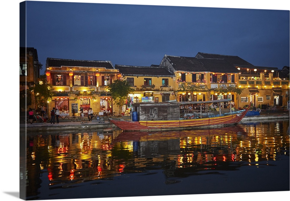 Boat and restaurants reflected in Thu Bon River at dusk, Hoi An (UNESCO World Heritage Site), Vietnam