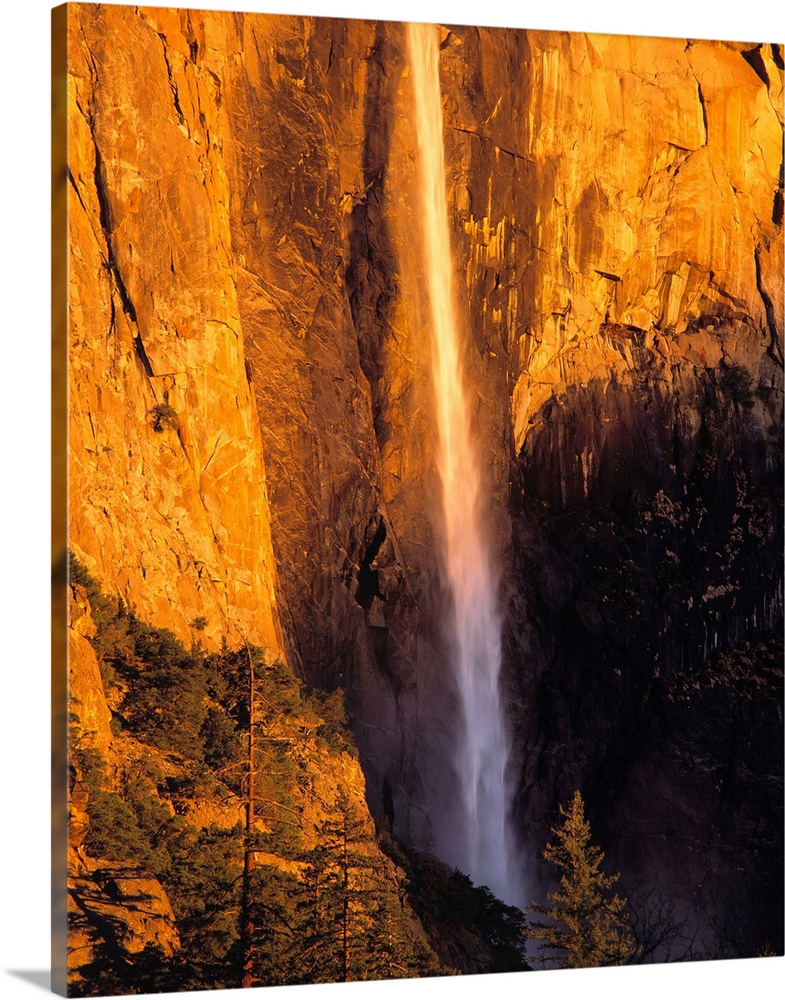 California, Yosemite National Park. Bridal Veil Falls follows a narrow path down the valley wall at Yosemite National Park...