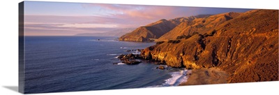 California, Big Sur, sunset casts a golden hue over the Coast Range