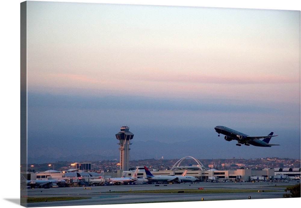 Boeing 767 airplane taking off at LAX airport, Los Angeles, California at dusk.