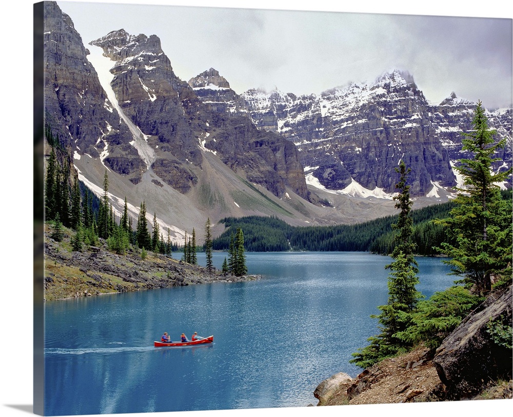 Canada, Alberta, Moraine Lake. A canoe glides across beautiful Moraine Lake in the Valley of the Ten Peaks, Banff NP, a Wo...