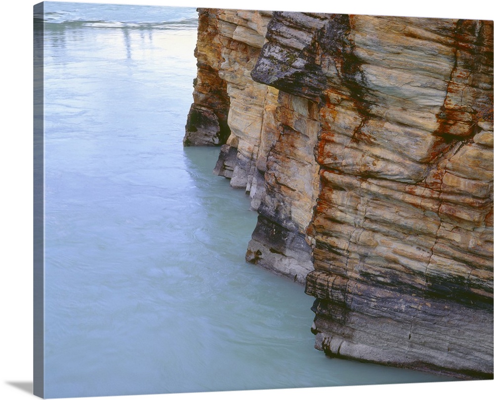 Canada, Alberta, Jasper National Park, Athabasca River flows alongside limestone cliffs near Athabasca Falls..