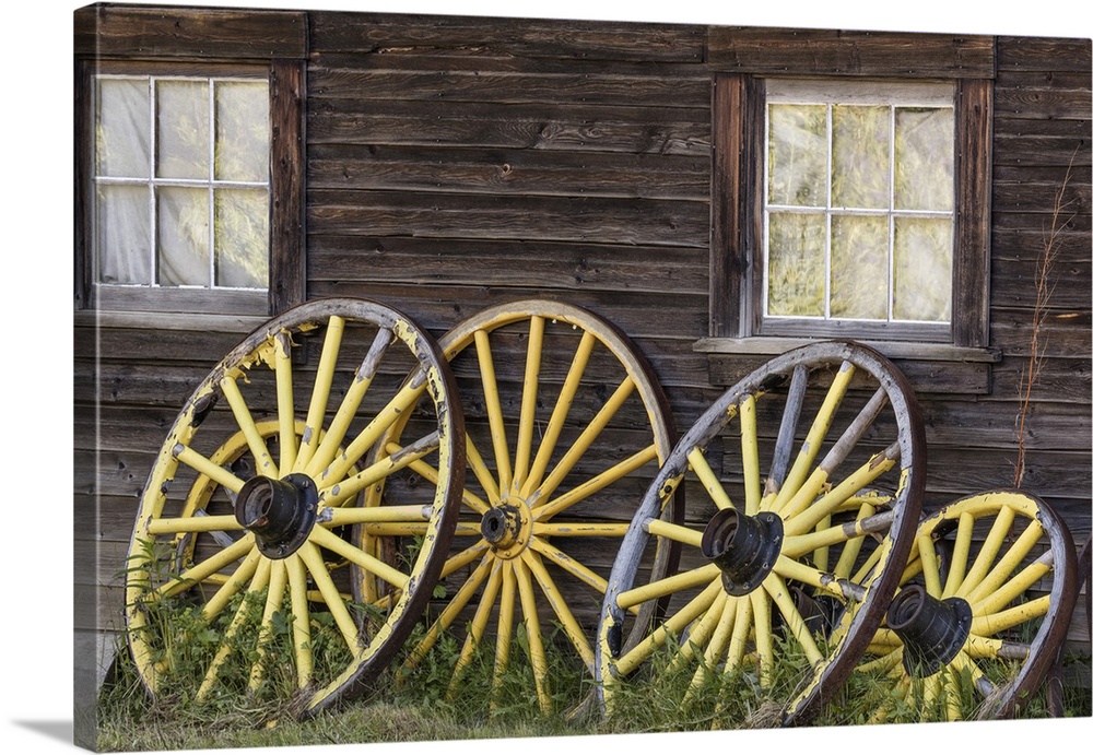 Canada, British Columbia, Barkerville. Wagon wheels lean on old building.
