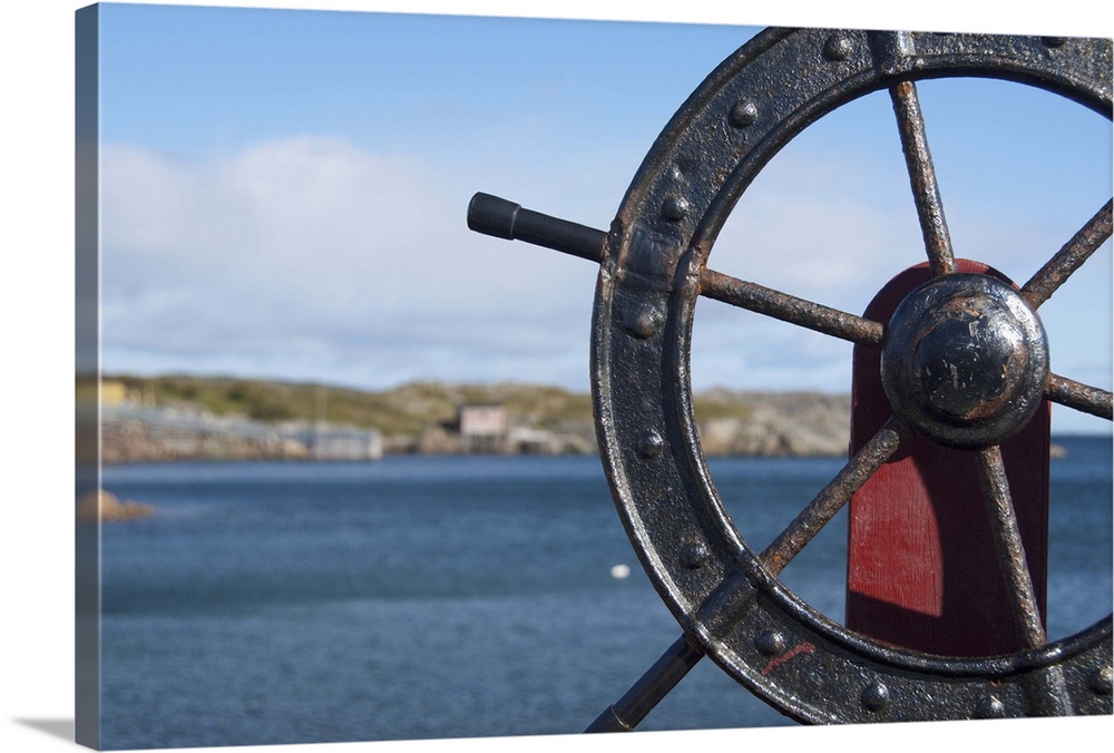 Canada, Newfoundland and Labrador, Twillingate. Fisherman's Point, boat wheel in front of scenic harbor area.