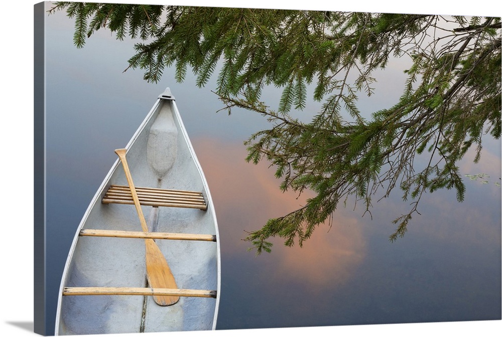 Canada, Quebec, Eastman. Canoe on lake at sunset.