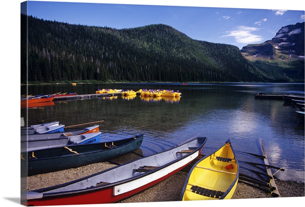 Canoes and pedal watercraft await tourists at Cameron lake in Waterton Lakes National Park in Alberta Canada