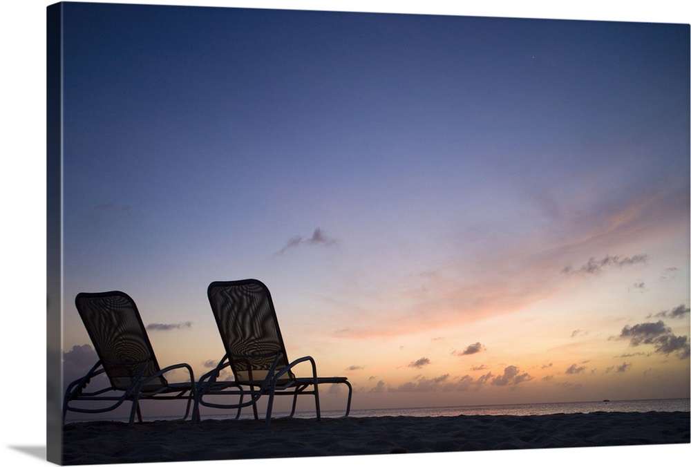 Cayman Islands, Grand Cayman Island, George Town, Beach chairs along Seven Mile Beach lining Caribbean Sea at dusk
