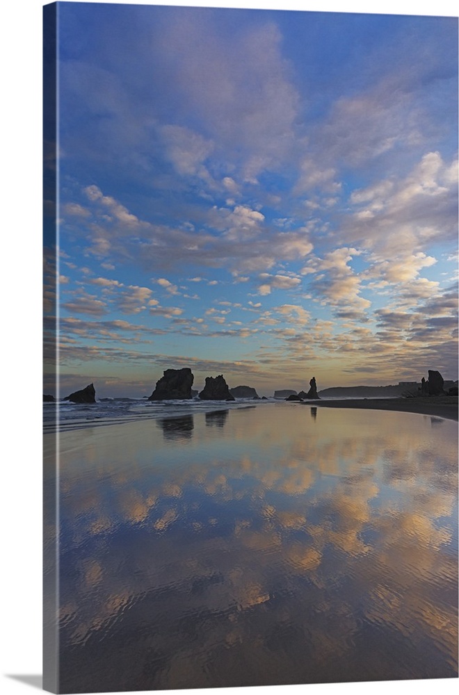 Clouds reflect in wet sand at sunrise at Bandon Beach in bandon, Oregon, USA