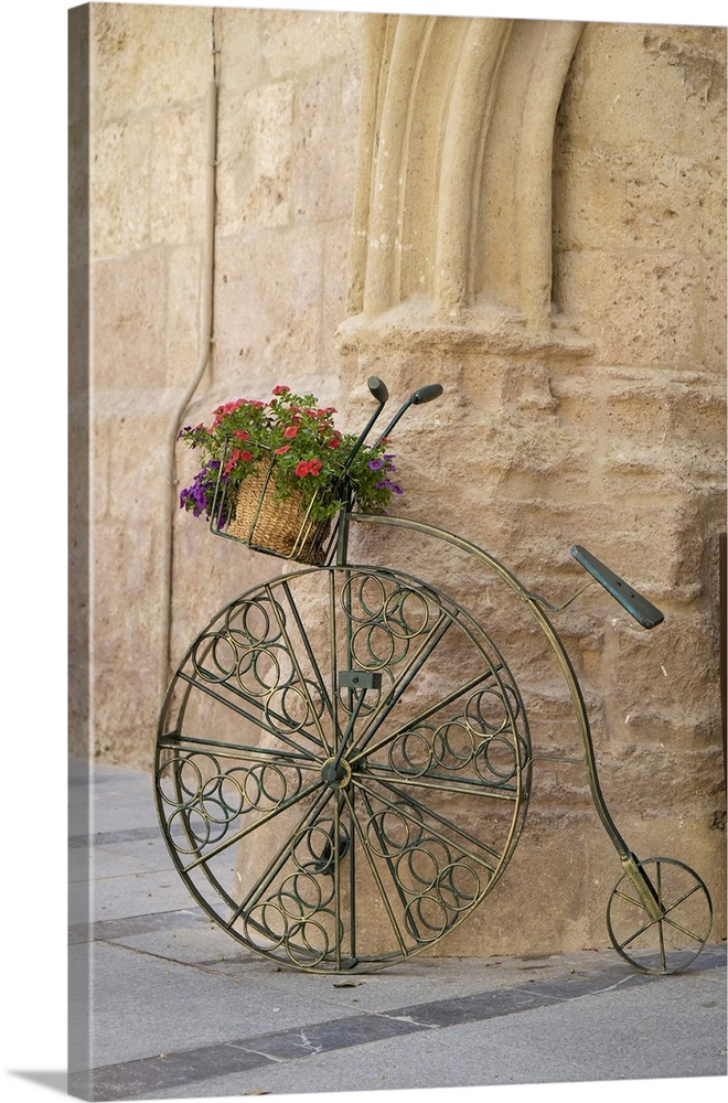 Cordoba, Spain. Bicycle planter in front of old stone building.
