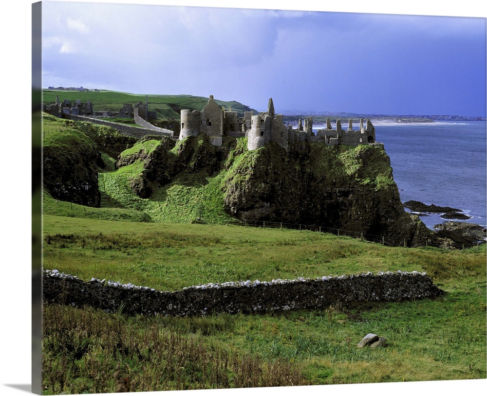 Northern Ireland, County Antrim, Dunluce Castle. Dunluce Castle rises from the emerald hills on Northern Ireland's Antrim ...
