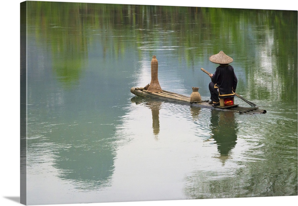 Fisherman on bamboo raft on Mingshi River with karst hills, Mingshi, Guangxi Province, China