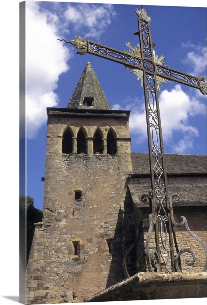 France: Averyon, Bozouls, Eglise Ste Fauste, Romanesque 12th century, steeple and bell tower behind wrought iron cross.