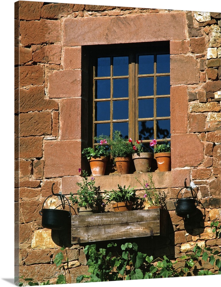 Europe, France, Collognes-la-Rouge. Colorful flower pots adorn a window in this home in Collognes-la-Rouge in the Dordogne...
