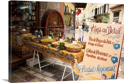 France, Riviera, Hyeres, Olive and wine display with sign advertising wine specials