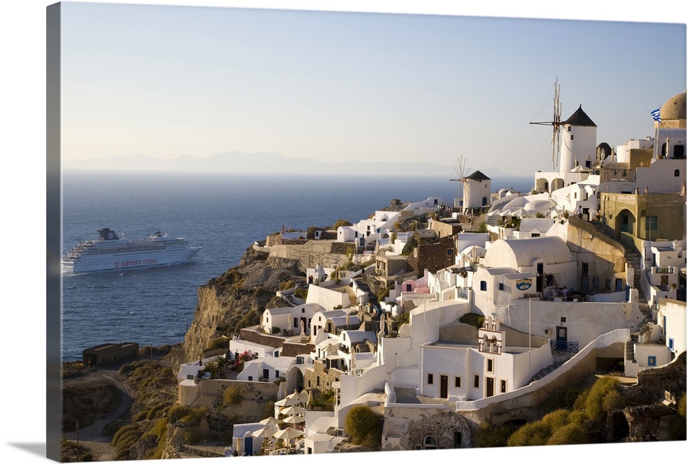 Greece and Greek Island of Santorini town of Oia in evening light with the many homes and businesses along the cliff edges...