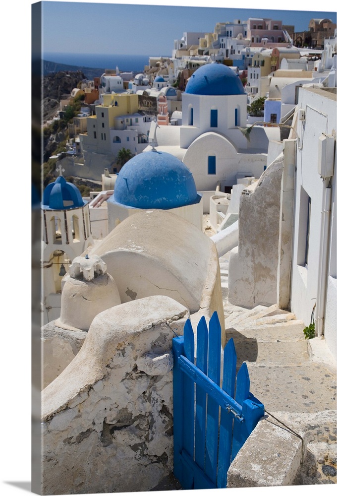 Greece and Greek Island of Santorini town of Oia with Blue Domed Churches with white and colorful buidling surrounding them