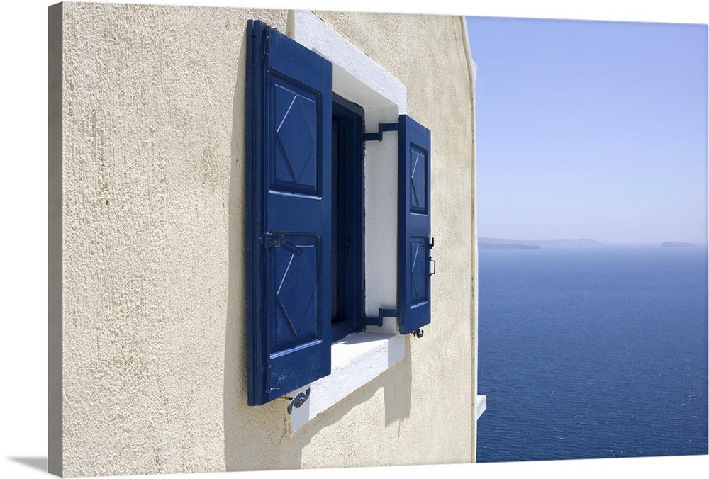 Europe, Greece, Santorini, Thira, Oia. Blue-shuttered window in pale yellow wall overlooking blue sea. Credit as: Bill You...