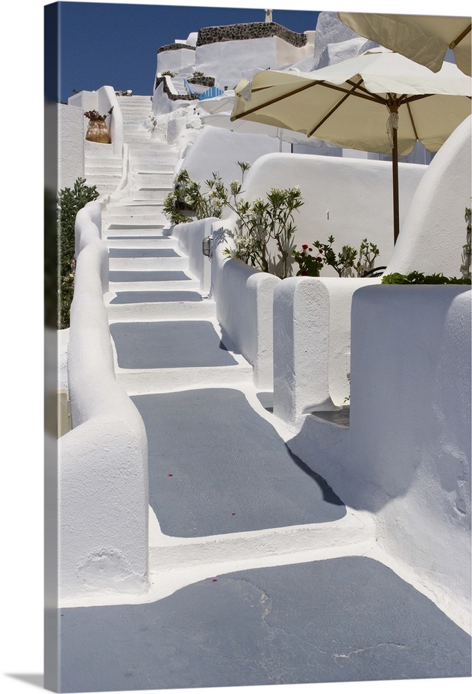 Europe, Greece, Santorini, Thira, Oia. Grey and white painted stairs leading past open patio umbrellas. Credit as: Bill Yo...