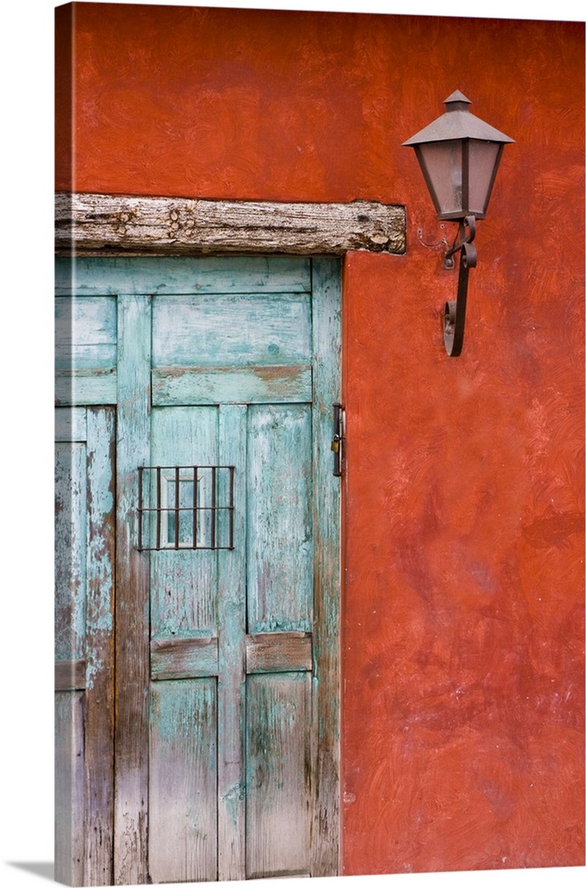 Central America, Guatemala, Antigua.  Aqua blue door against colorful red wall in Antigua.