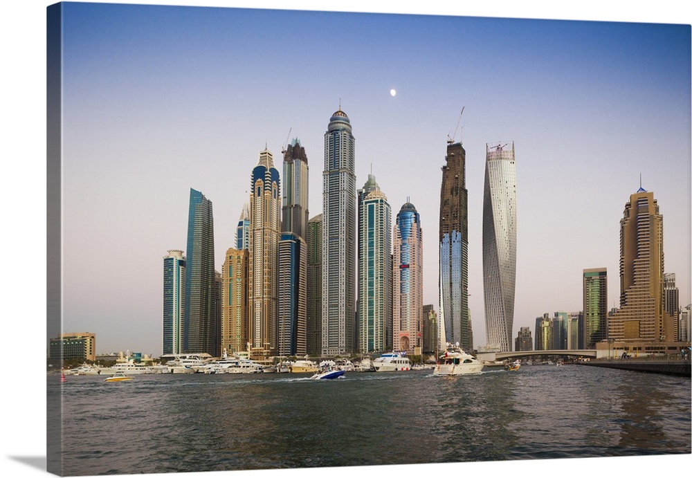 UAE, Dubai, Dubai Marina, high rise buildings including the twisted Cayan Tower, with moonrise, dusk