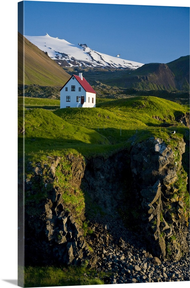 House near basaltic columns with Snaefellsjokull Volcano in the background.