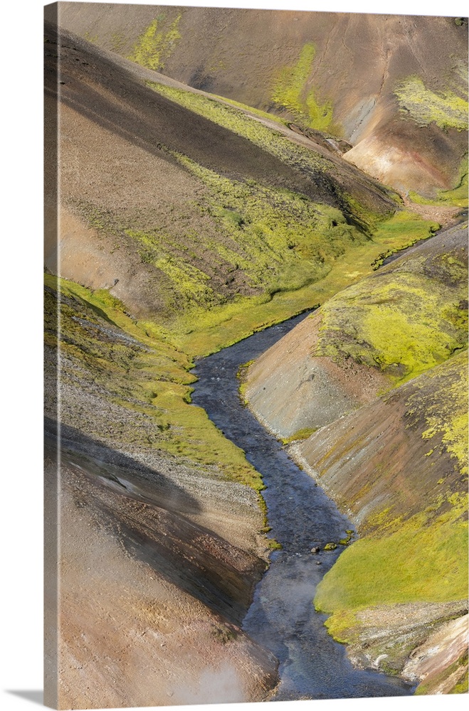 Iceland, Fjallabak Nature Reserve, Landmannalaugar. A small river flowing through the multicolored lava hills that are cov...