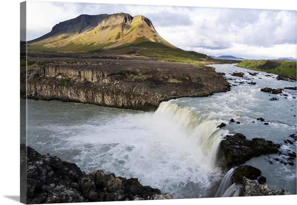 Iceland, Southern Highlands, Pjorsa River. The Pjorsa River flowing into the Pjofafoss waterfall with Mount Burfell in the...