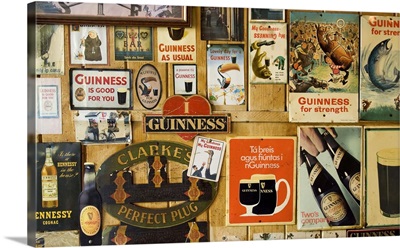 Ireland, Carrick. Vintage Guinness and other signs decorate the interior walls of a pub