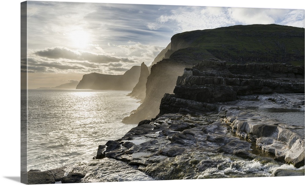 The west coast near Traelanipa with waterfall Bosdalafossur at sunset. The island Vagar, part of the Faroe Islands in the ...