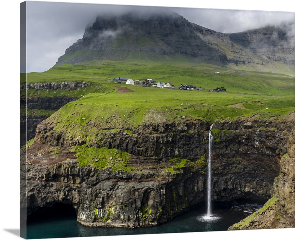 The waterfall near Gasadalur, one of the landmarks of Faroe Islands. The island Vagar, part of the Faroe Islands in the No...